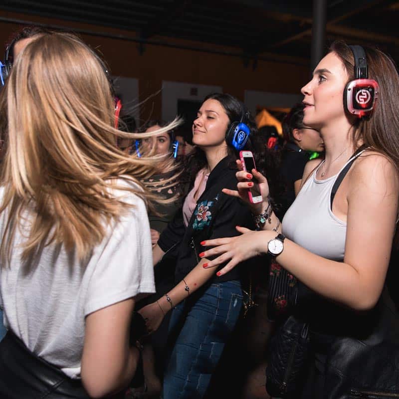 Chicas bailando con cascos de silent party en una despedida