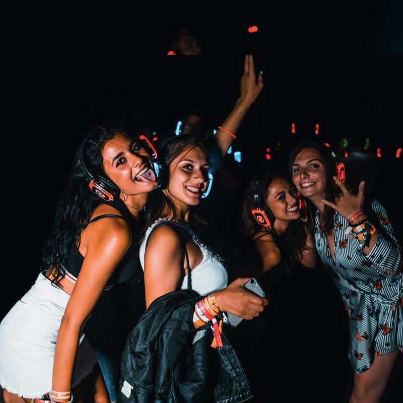 Amigas sonriendo con cascos de silent party en un cumpleaños