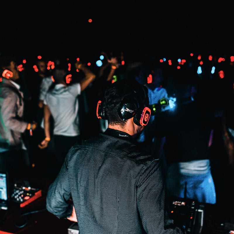 Persona pinchando música mientras el público escucha con cascos