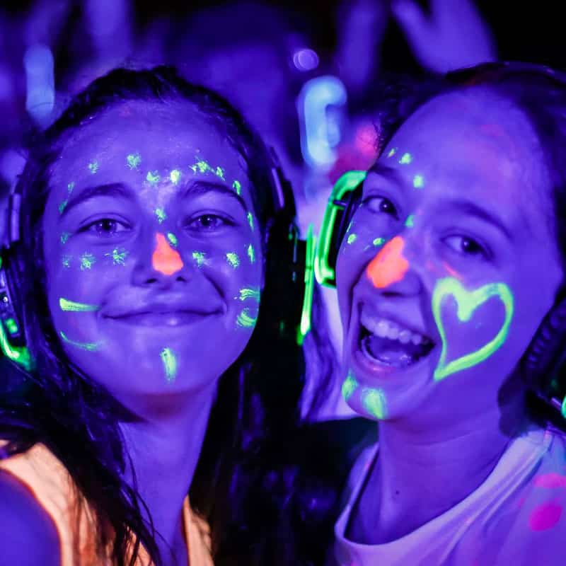 Chicas con maquillaje fluorescente y cascos de silent party