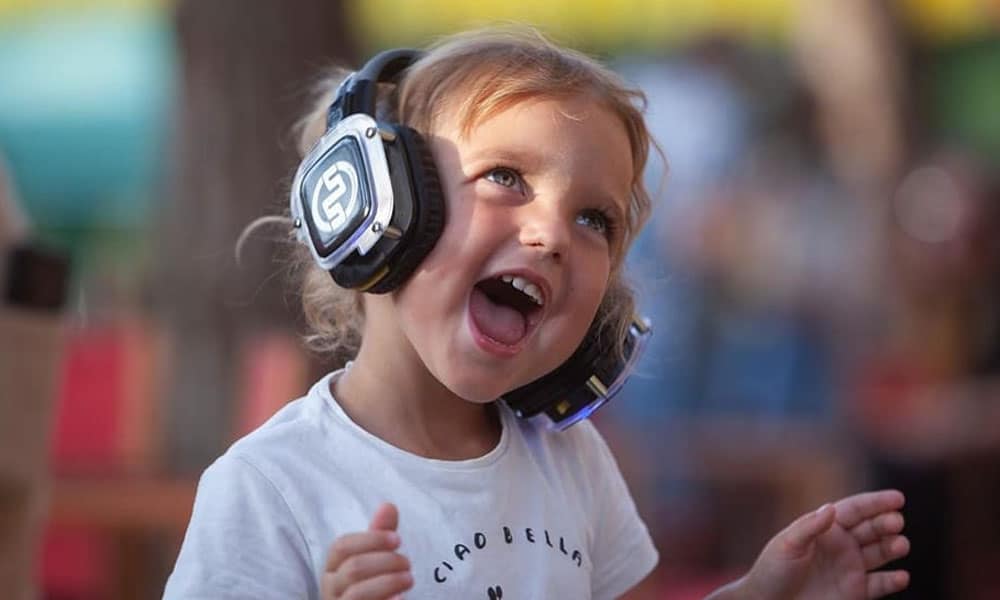 Niña sonriendo con cascos de silent party iluminados